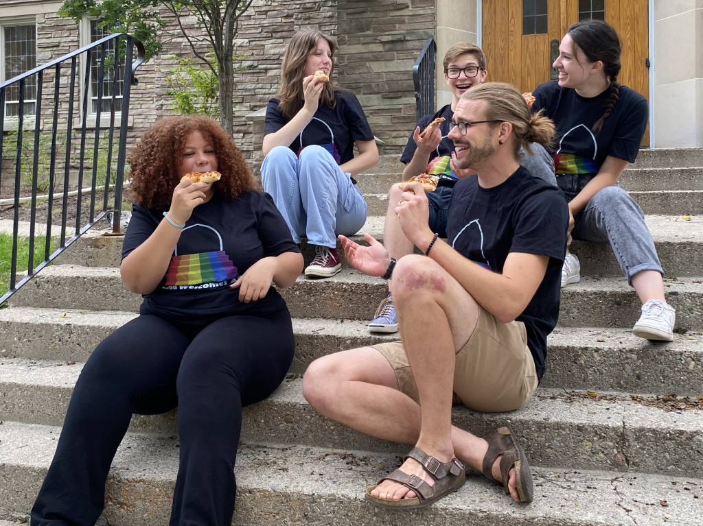 Youth eating pizza on church steps.