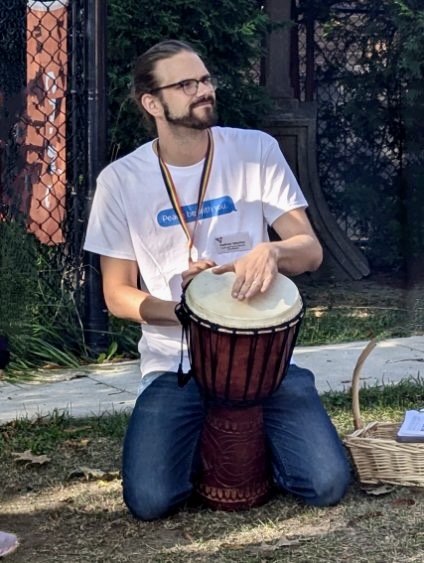 Bearded man plays djembe.